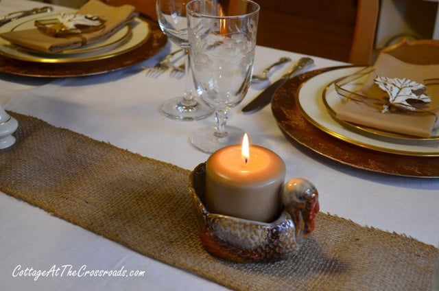 Burlap runner with a turkey candleholder.