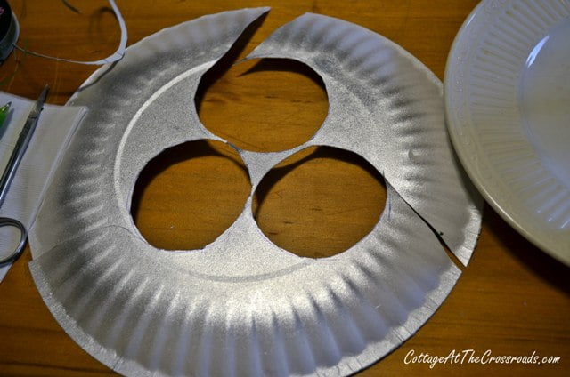 Circles cut out of a paper plate painted silver