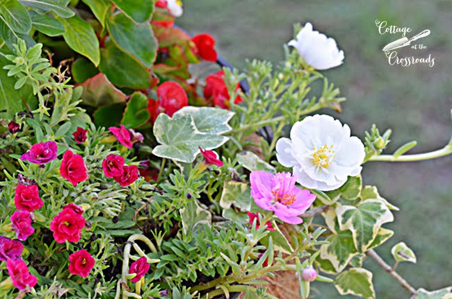 Flower baskets mounted on wooden posts | cottage at the crossroads