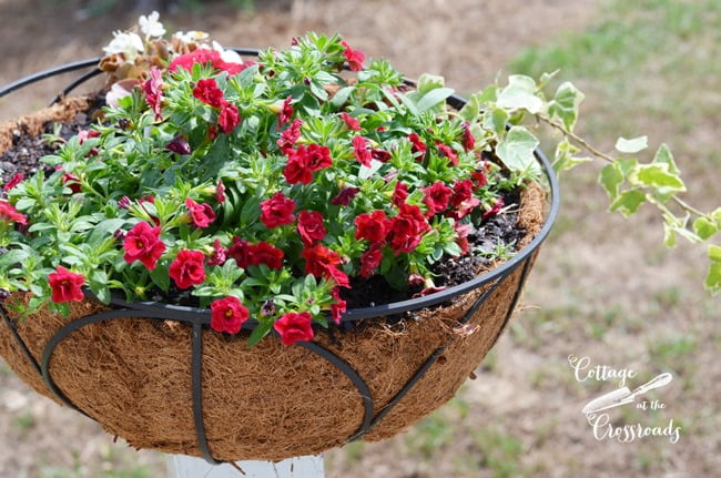 Flower baskets mounted on wooden posts | cottage at the crossroads