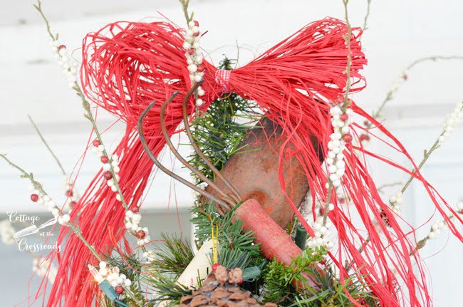 Cottage christmas porch tree with vintage gardening tools as a tree topper