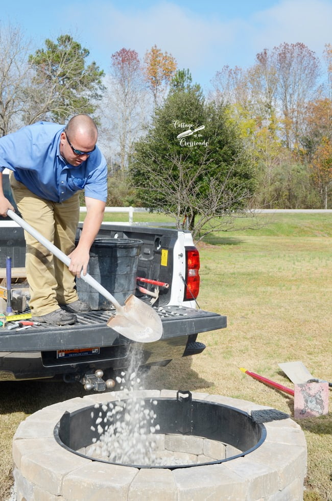 Shoveling pebbles into the belgard fire pit