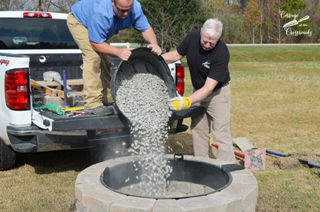 Pouring pebbles into the belgard fire pit