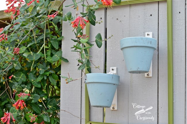 Terracotta pots attached to a wooden fence with potholders