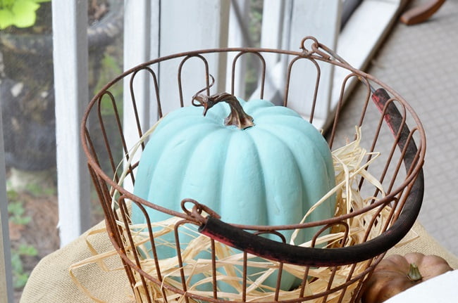 Aqua pumpkin on an autumn decorated porch