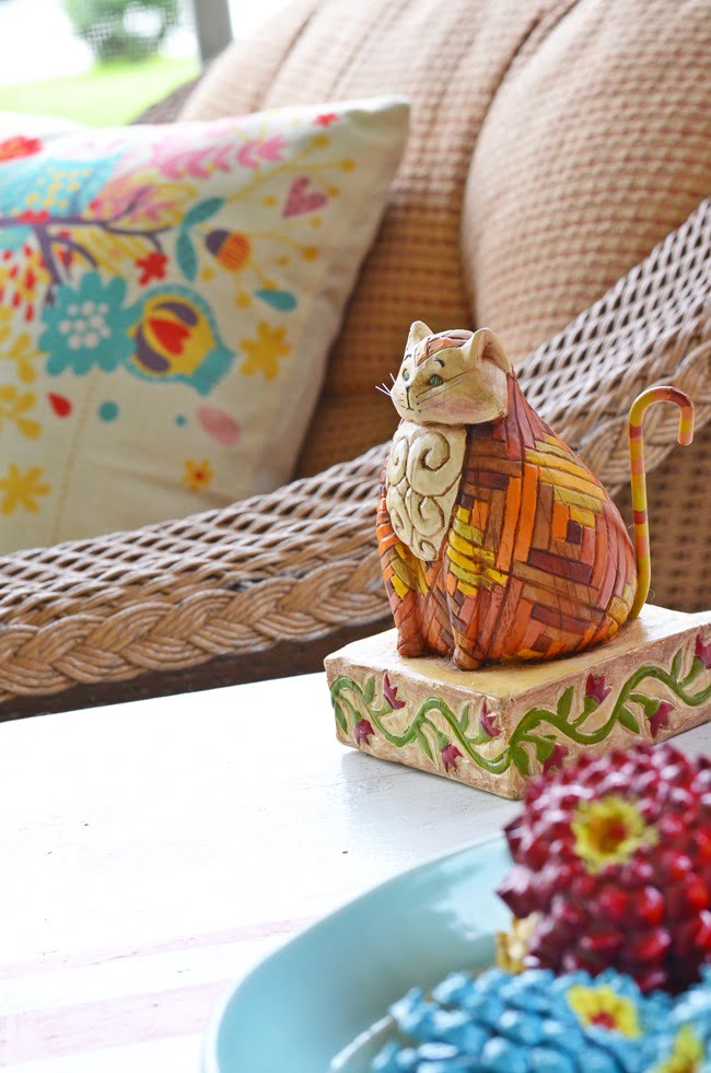 Cat figurine on an autumn porch