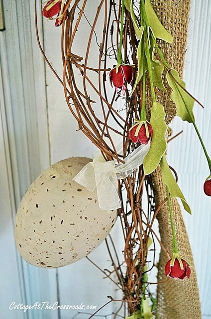 Painted plastic easter eggs used in decorating garland around a front door | cottage at the crossroads