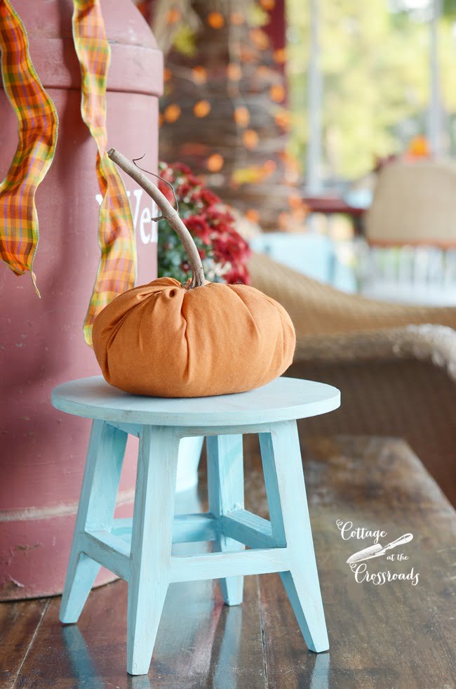 Handsewn orange pumpkin on an autumn front porch