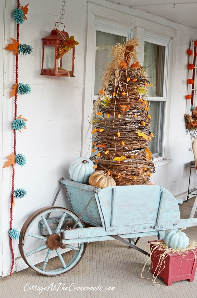 Handmade grapevine tree in an aqua wheelbarrow used on an autumn front porch