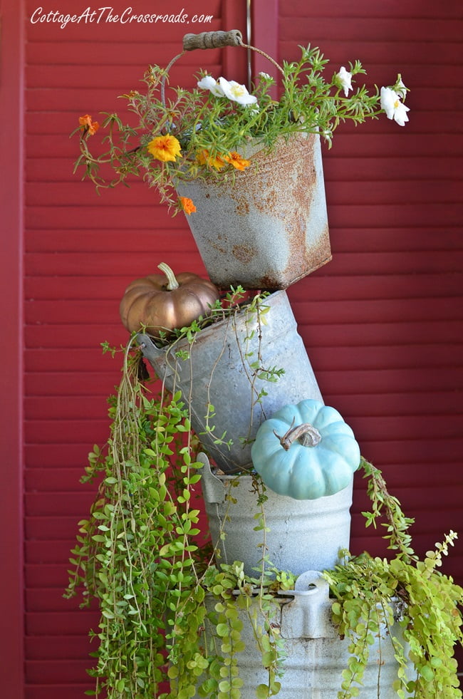 Topsy turvy buckets on an autumn decorated front porch