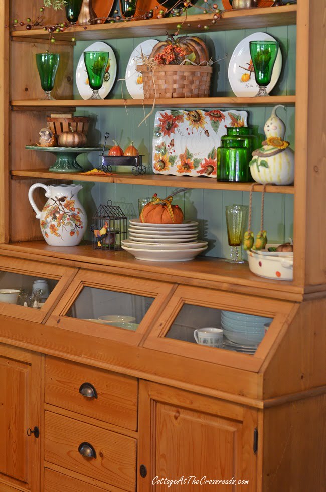 Pine farmhouse cupboard decorated for fall