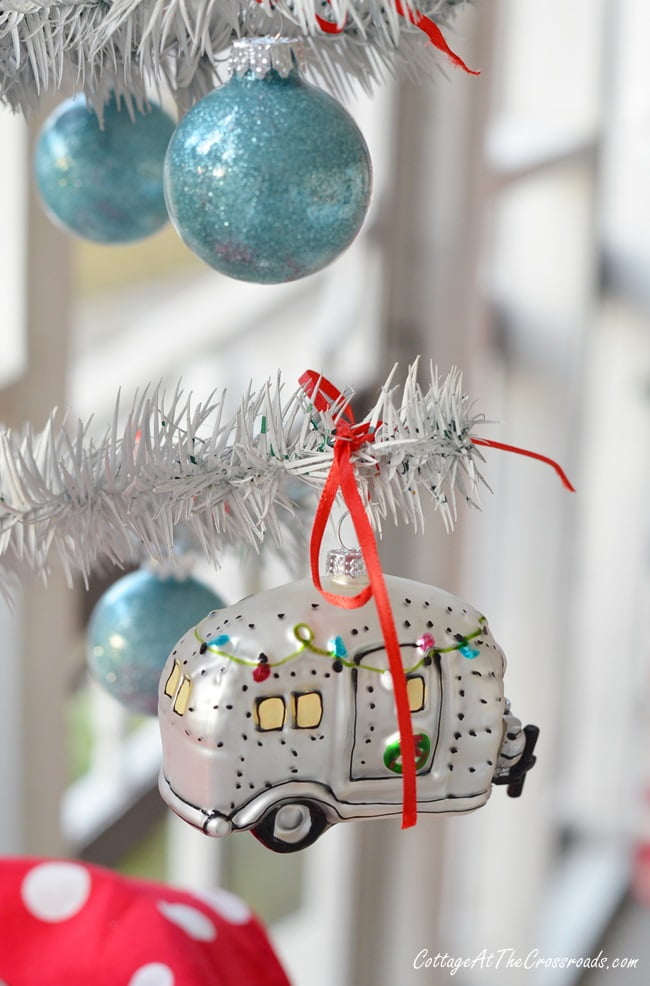 Vintage camper christmas ornament on a camping themed porch