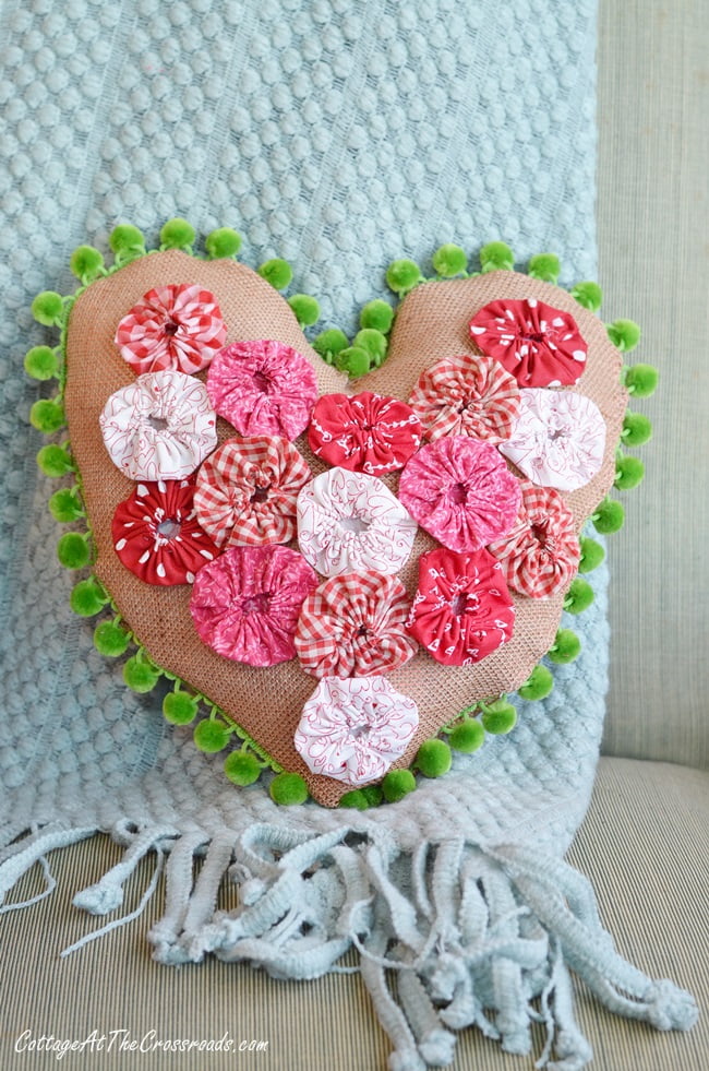 Heart shaped pillow with red and white fabric yo-yos