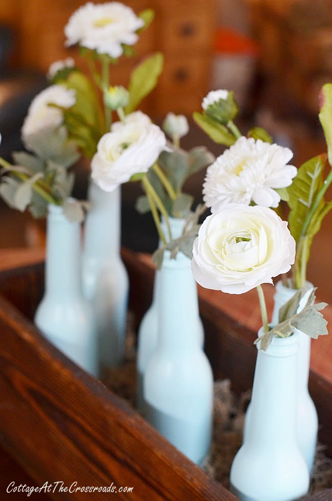 Faux flowers in a painted bottle spring centerpiece