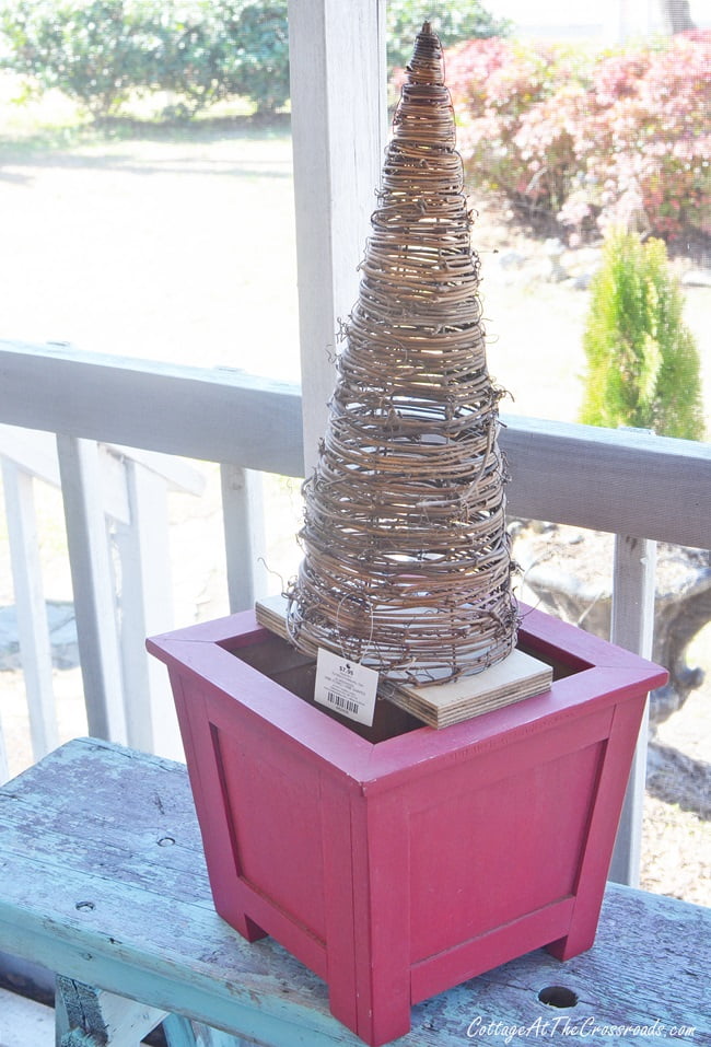 Grapevine cone on top of a red wooden planter