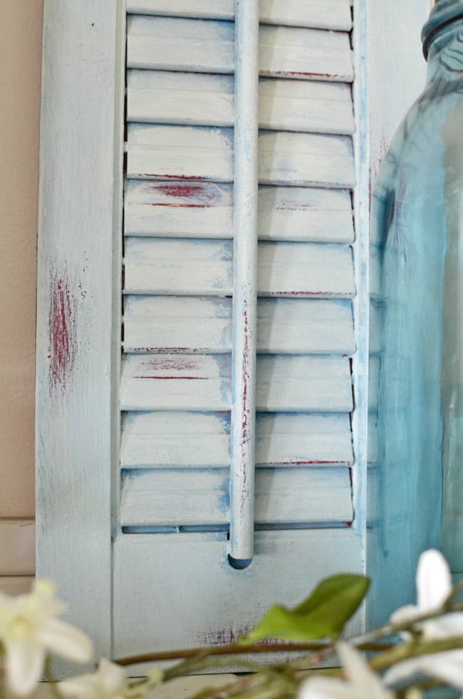 Old wooden shutter painted blue over red with some distressing