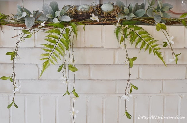 Spring mantel with ferns and a blooming vine