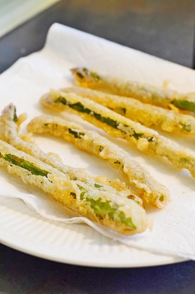 Fried asparagus draining on paper towels