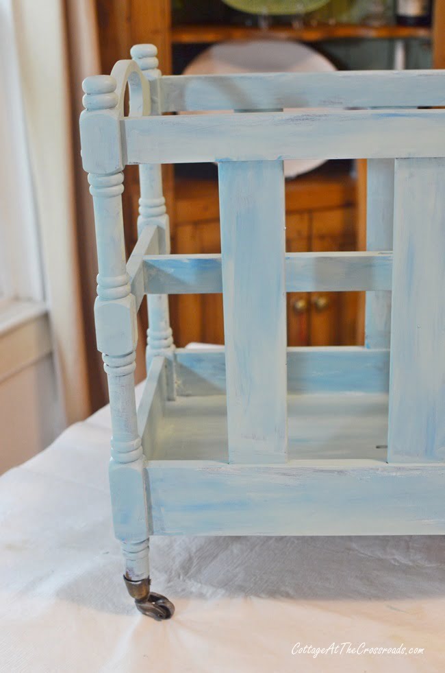 Second coat of paint on a vintage wooden magazine rack