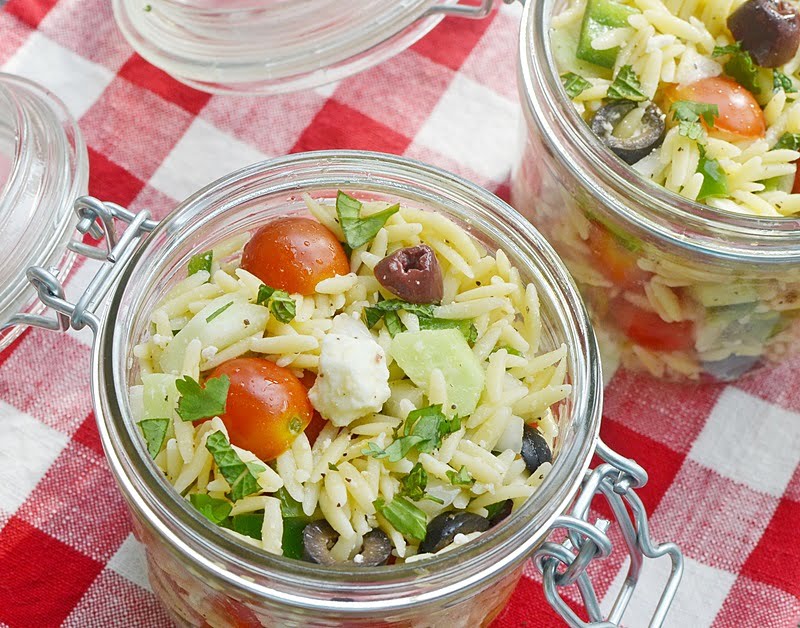 Lemony orzo salad in a glass container