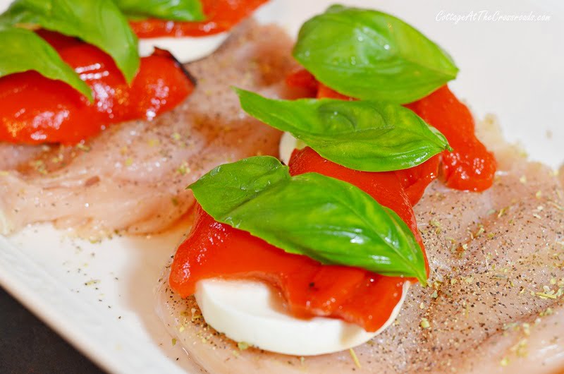 Fresh basil leaves, roasted red peppers, and fresh mozzarella on chicken breasts