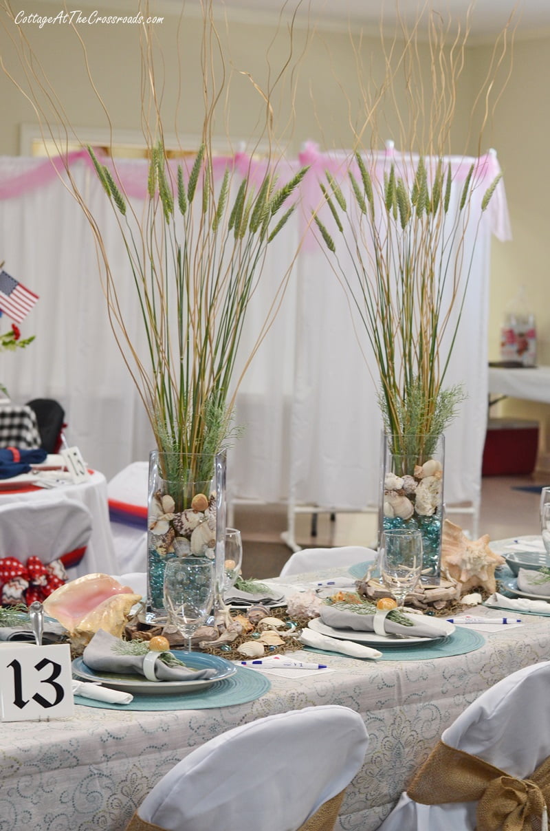 Tall grasses used as floral centerpieces in a coastal themed tablescape