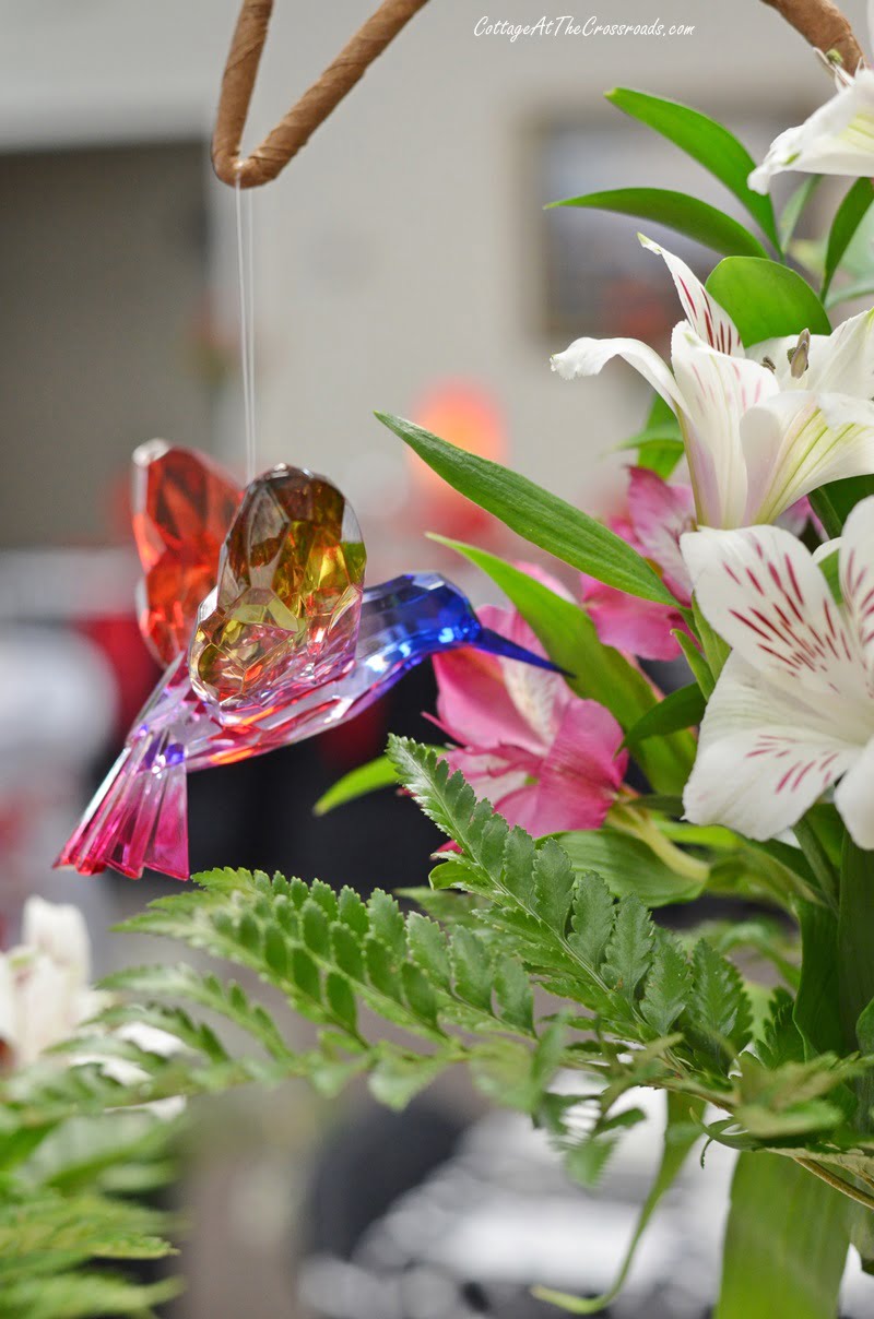 Glass hummingbird hanging in a floral centerpiece