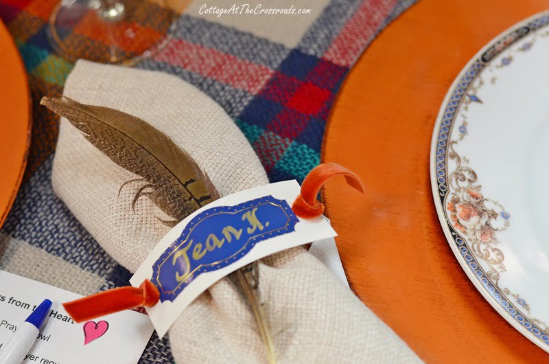 Pheasant feather tucked into place card napkin ring