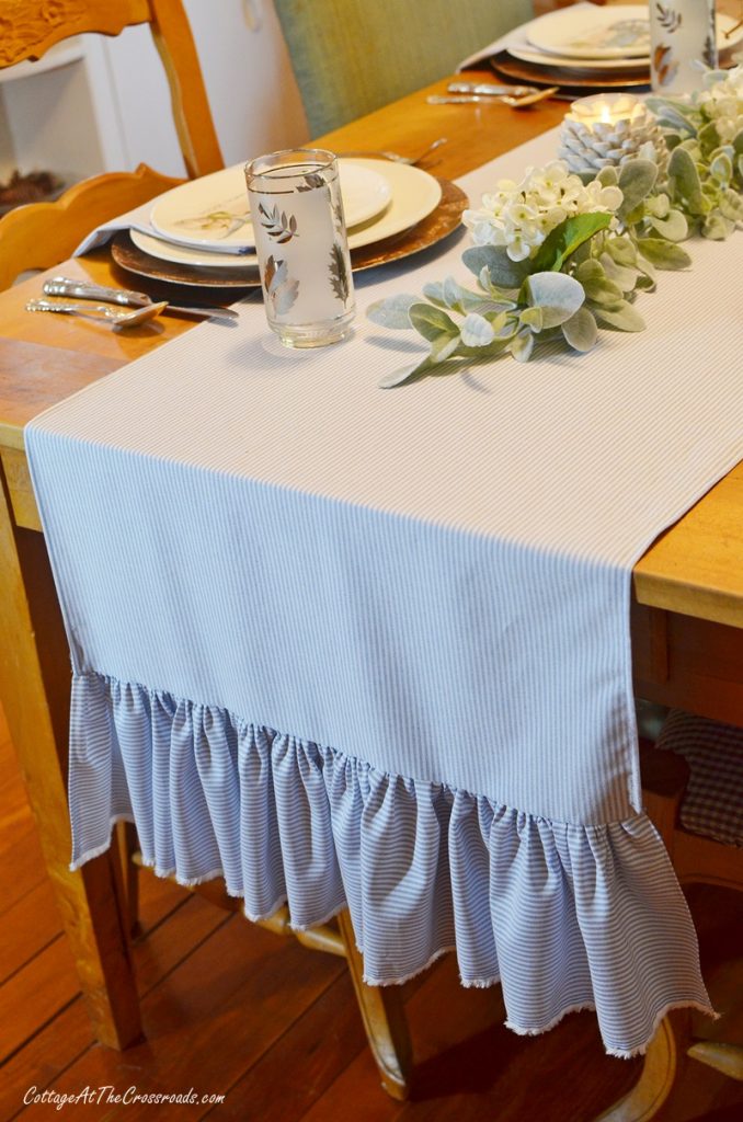 Thanksgiving tablescape using blue and white table runner with ruffled ends