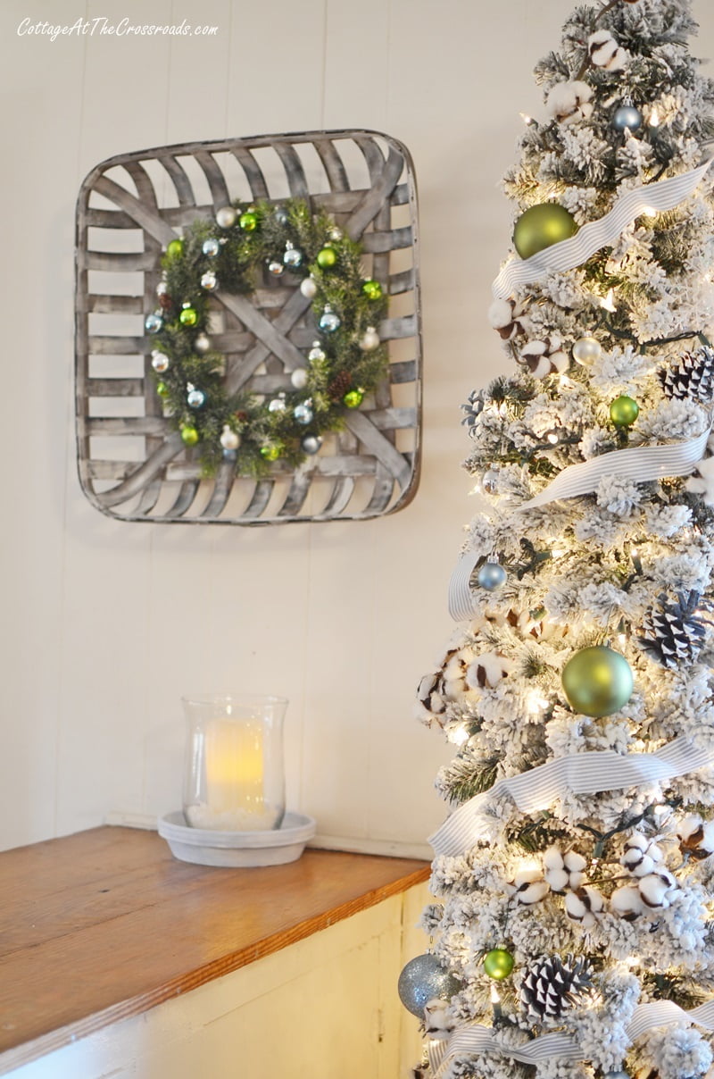 Ornament wreath beside a christmas tree