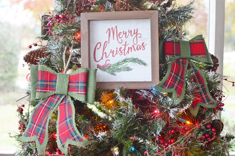 Merry christmas wooden sign hanging on a christmas tree