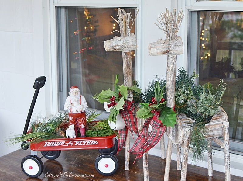 Santa in a red wagon on a christmas front porch