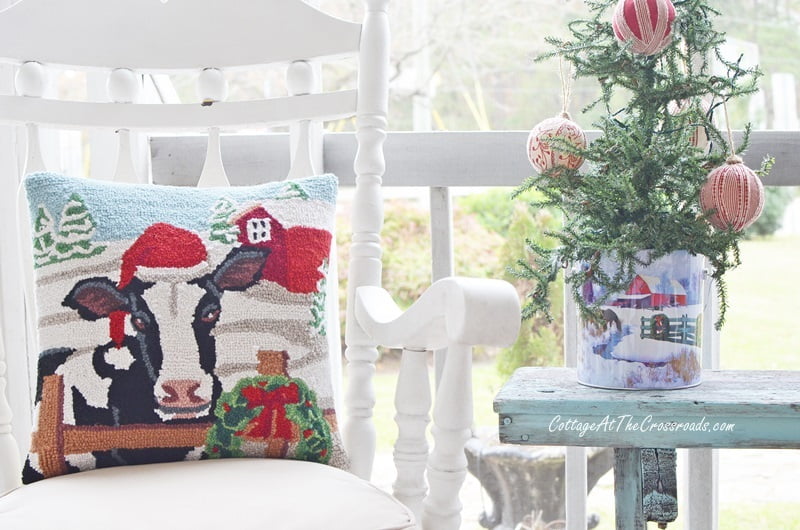 Cow pillow on a christmas front porch