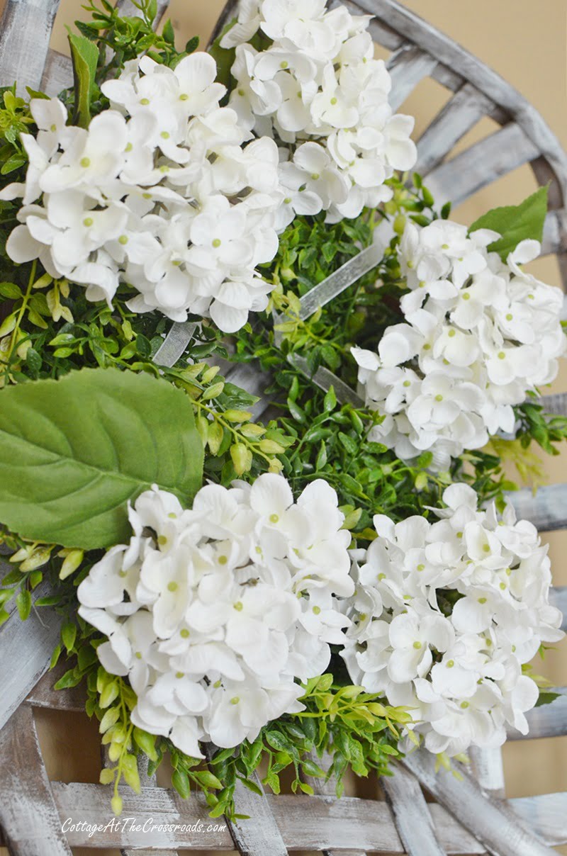 White hydrangea farmhouse wreath in a tobacco basket