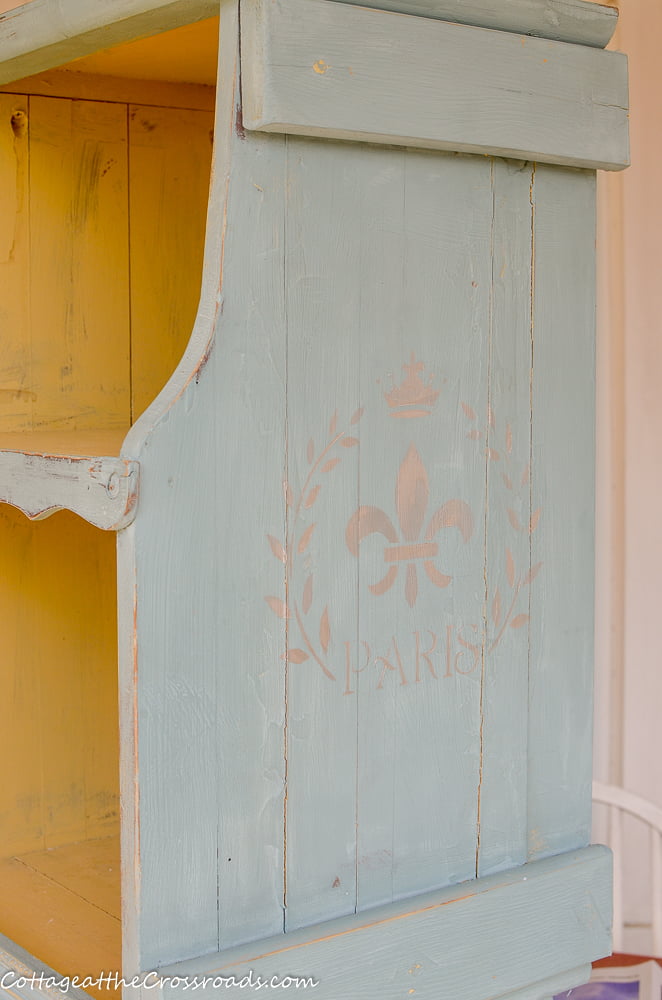 Fleur-de-lis stencil on the side of a magazine rack