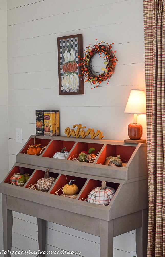 Pumpkin lamp on a cubby filled with pumpkins