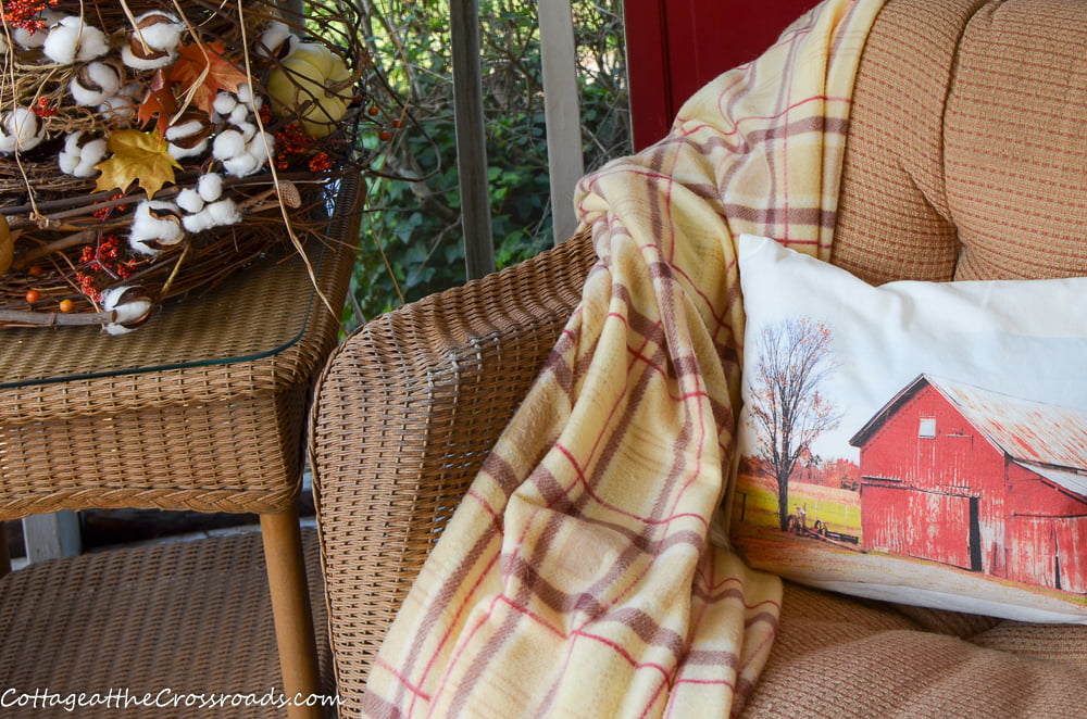 Red barn pillow on a fall porch