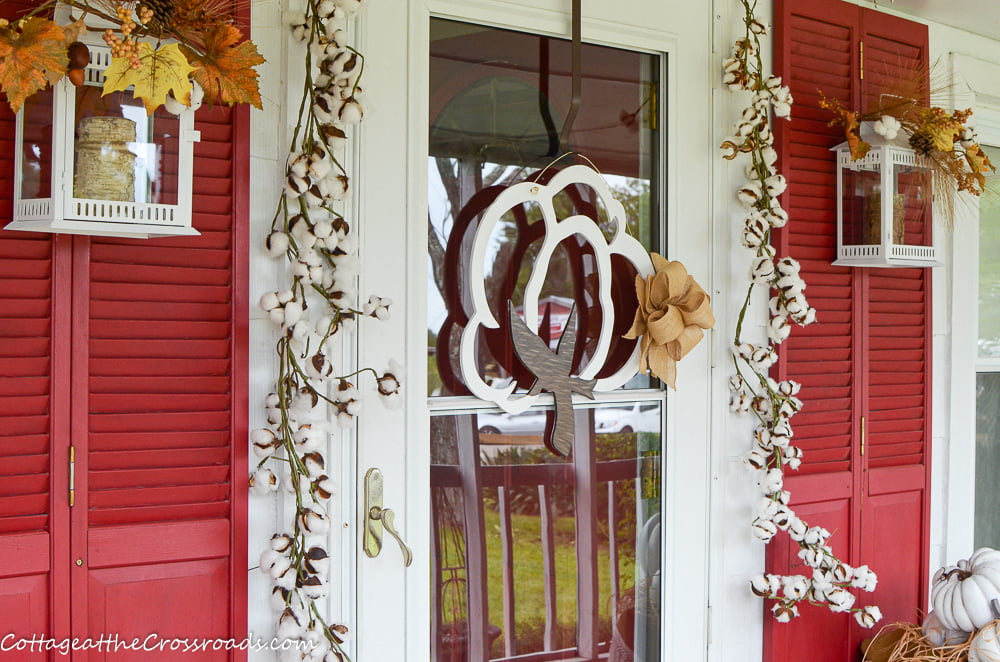 Wooden cotton doorhanger on a cotton themed fall front porch