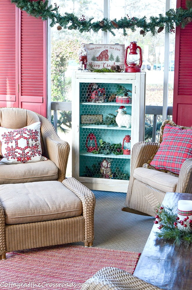 Country cottage christmas front porch decorated with red, aqua, and plaid