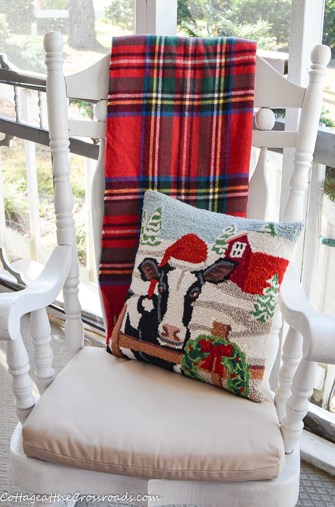 Plaid throw and pillow in a rocking chair on a christmas porch