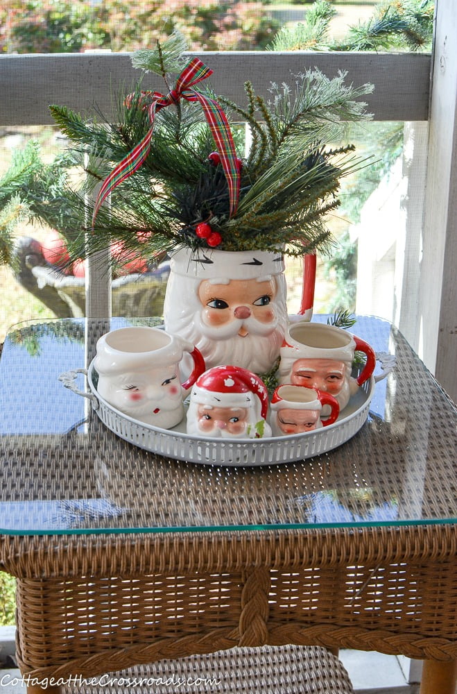 Vintage santa mugs and pitcher on a christmas porch