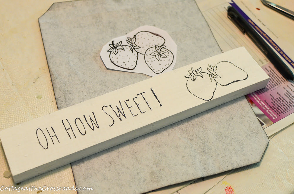 Traced text and strawberries on scrap wood