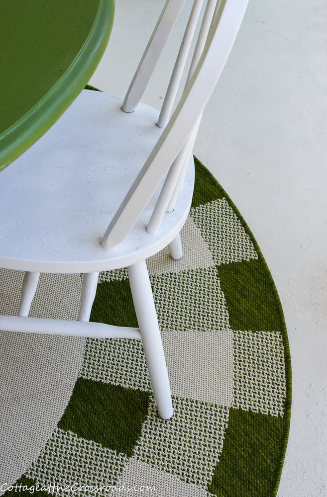 Painted concrete porch floor with a green buffalo checked rug