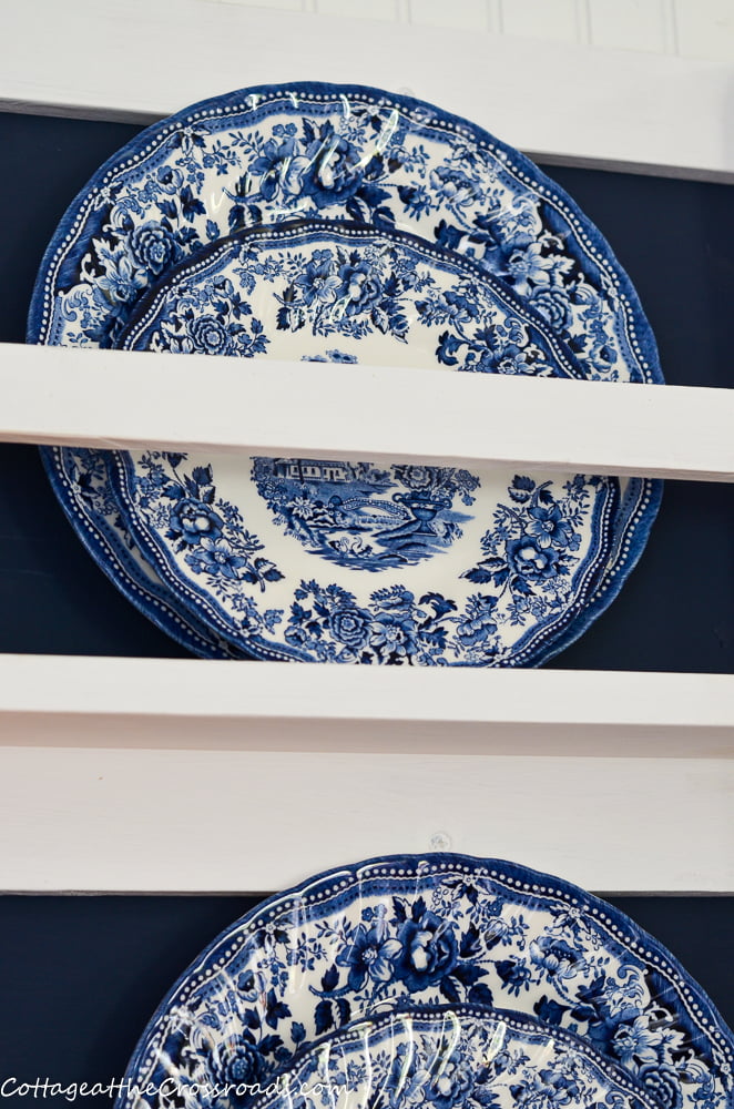 Blue and white china in a wooden plate rack