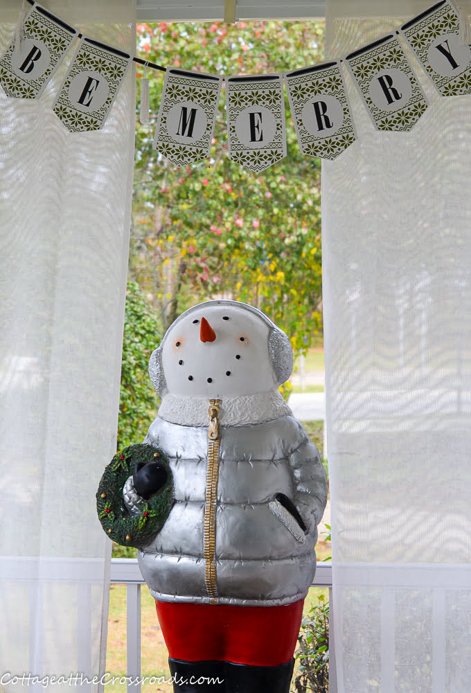Be merry sign above snowman