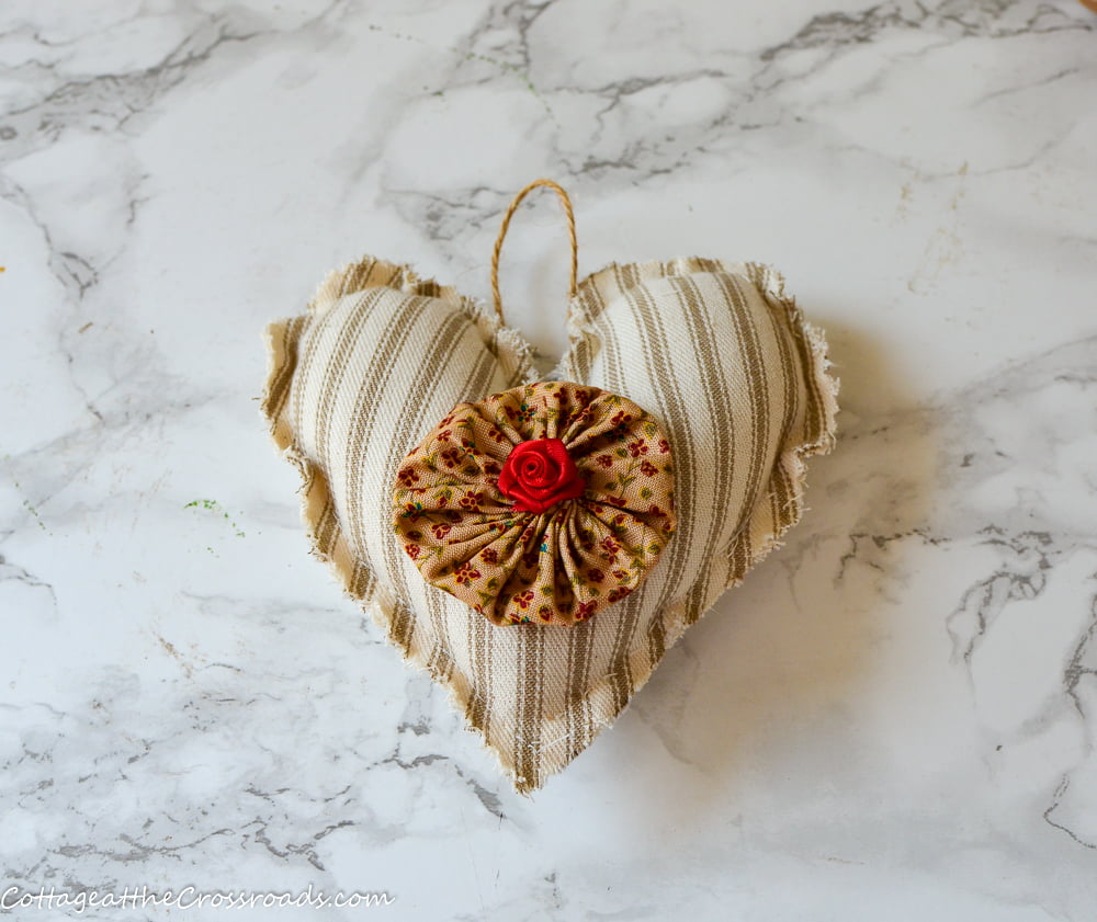 Fabric heart made with ticking with a yo-yo