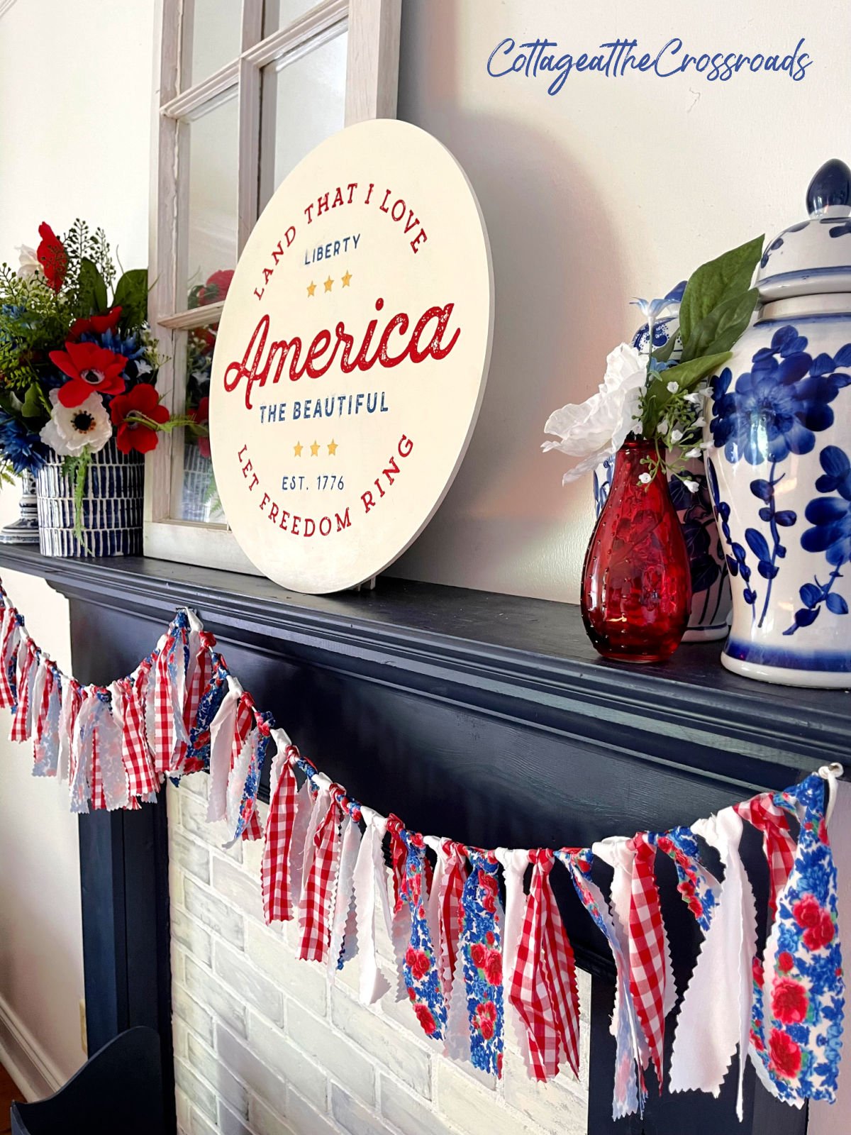 Red, white, and blue garland and other patriotic decorations on a navy mantel