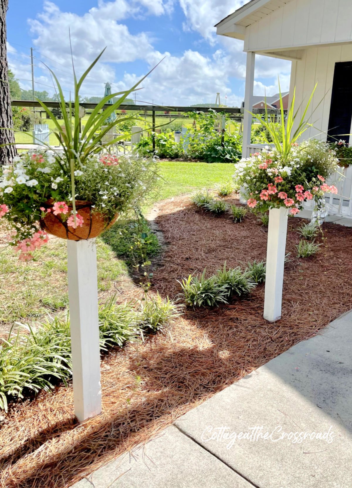 Flower baskets mounted on white wooden posts