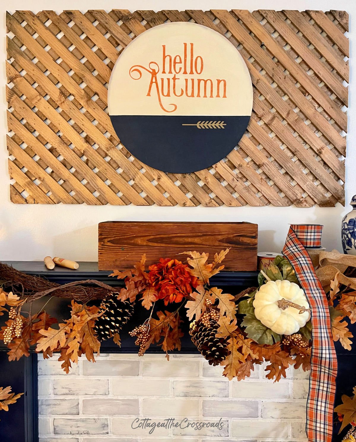 Wooden round with the words hello autumn mounted on a wood lattice panel