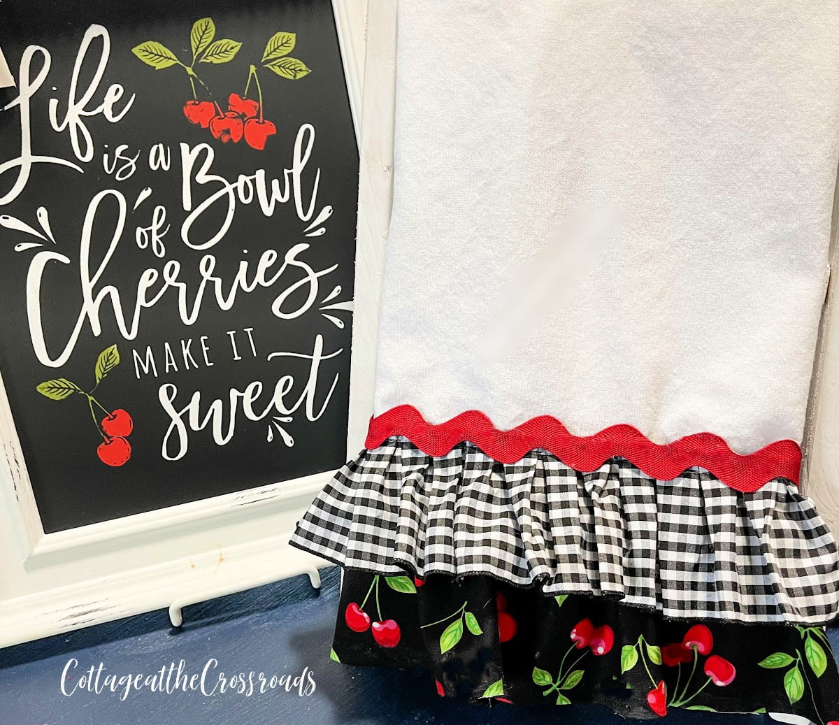 Ruffled tea towel beside a sign that says life is a bowl of cherries